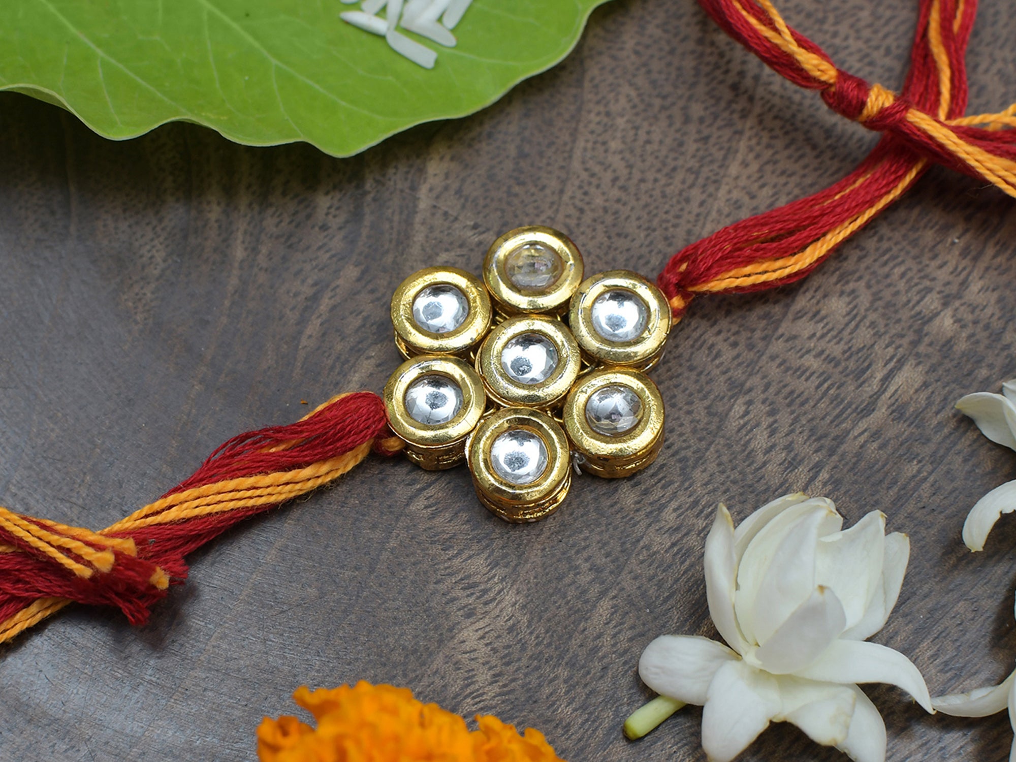 Kundan Floral Gold Tone Kundan Rakhi With Red Yellow Cotton Thread